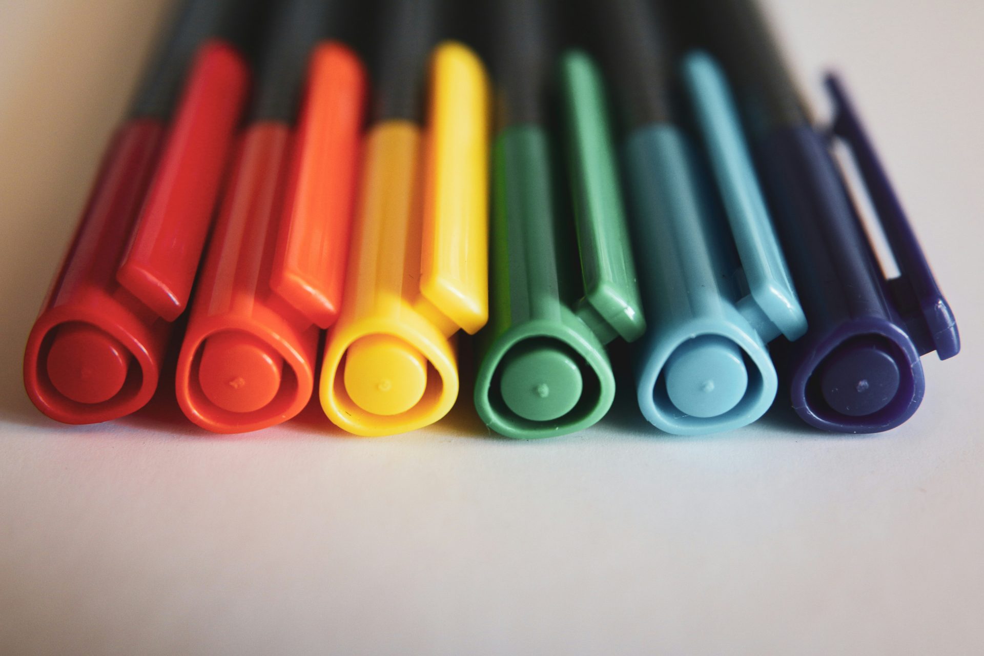 A row of colored markers sitting on top of a table